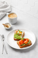 Bread toast with avocado, salmon, eggs, micro greens. Morning concept. Types of toast for breakfast.