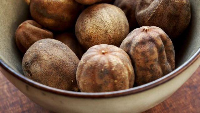 Persian dried whole limes (limu omani) in bowl. Table spin.