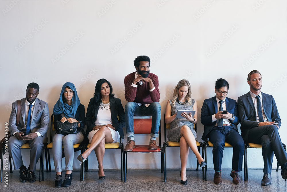 Poster well hes feeling very confident. shot of a group of confident businesspeople waiting in line for the