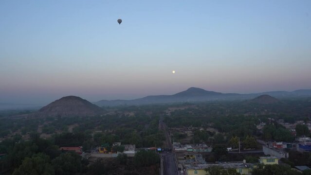 Early morning flying on a hot air balloon in the sky with a view of the pyramids in distance