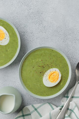 Spinach cream soup with boiled egg top view