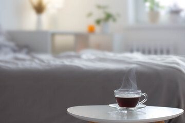 glass cup of coffee on white table in bedroom