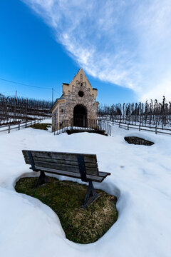 The Chapel of Count Spaur immersed in the snow-covered countryside of the Non Valley. Flavon, Trentino, Italy.