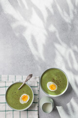 Spinach cream soup with boiled egg top view