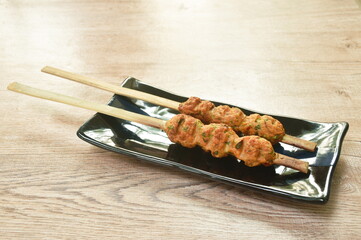 grilled Thai fish cake or Jang Lon stabbing in wooden stick on plate - obrazy, fototapety, plakaty