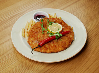 schnitzel with french fries, sauce and pepper