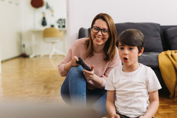 mother and son are playing video games at home