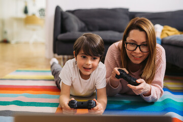 mother and son are playing video games at home