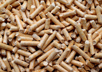 Background of wood filler pellets for animals. Litter for cats and rodents close-up