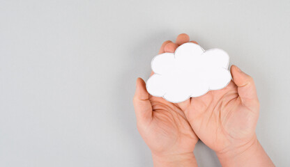 Holding a white cloud in the hand, empty copy space for text, gray background, communication and marketing concept, being connected, networking