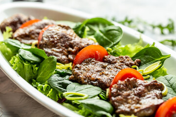 Warm salad with chicken liver, Baby spinach, tomatoes and balsamic dressing. Food recipe background. Close up