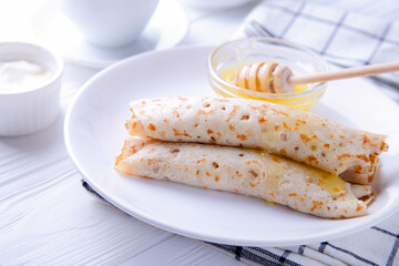 Pancakes with cottage cheese and honey on a white background