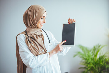 Young muslim person doctor woman face on isolated white background concept islamic healthcare in tech research hospital health medical care, nurse worker hijab hold tablet ipad