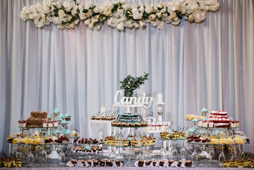 Candy bar. Sweet table, buffet. A plates of cakes and muffins. Dessert table for party goodies. Party reception, decorated delicious in the restaurant.