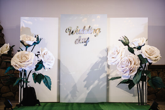 Wedding arch, wall, photo area. Rustic photo zone with paper flowers. Hand made wedding decorations. Place for taking pictures, photography.