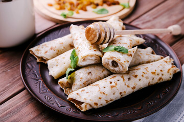 Pancakes with cottage cheese, raisins and honey on a wooden background