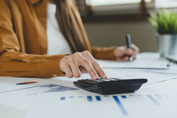 Close up hand of stress asian young employee business woman calculate tax income and expenses,...