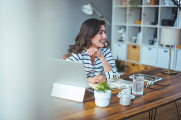 A beautiful business woman in casual clothes works on a virtual computer in the office desk. Small business owner people employed free online we are marketing e-commerce telemarketing
