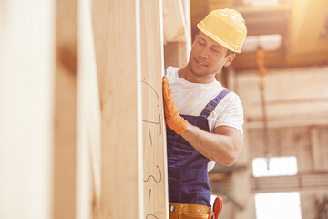 Handsome man builder working at house building construction site