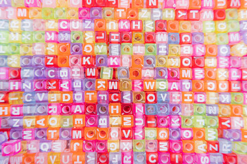 Colorful plastic alphabet beads for background. Education concept.