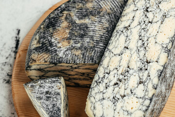 Asiago italian cheese with cuttlefishink on a wooden board. banner, menu, recipe place for text, top view