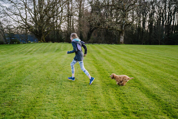 Child girl runs, has fun and plays with her dog 