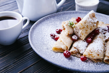 Pancakes with cottage cheese, cranberries and honey on a gray plate