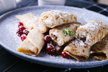Pancakes with cottage cheese, cranberries and honey on a gray plate