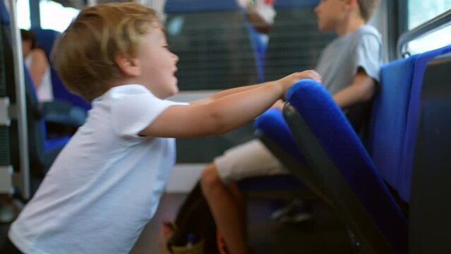 MIschievous children traveling by train kids not behaving playing with seats