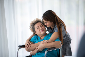 health insurance concept, young Asian woman are visit her senior family patient at hospital room, grandmother sitting on wheelchair are sick and having health care support by doctor and nurse