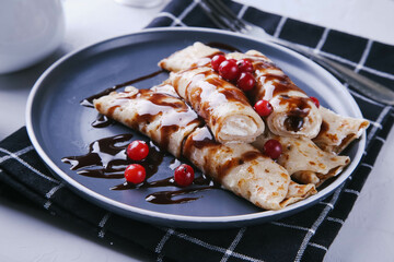 Pancakes with cottage cheese and cranberries covered with chocolate topping