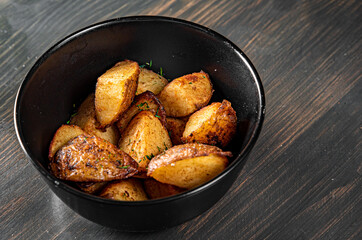roasted potato in bowl on black wooden table background