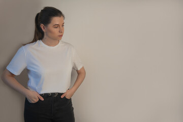 Cute young woman in blank white t-shirt standing isolated over background mockup copy space