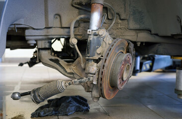 Car suspension repair in a modern car service. The wheel was removed from the car and the...