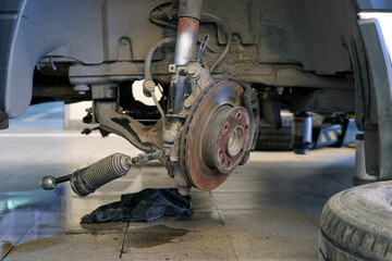 Modern car repair. The wheel was removed from the car and the steering and suspension were partially disassembled.