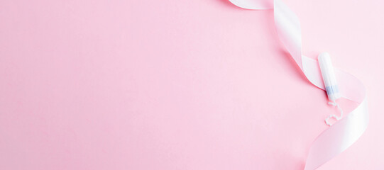 Menstrual tampon feminine hygiene. Pink ribbon with menstrual tampon on pink background....