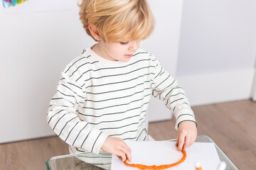 Boy molding mold plasticine at table