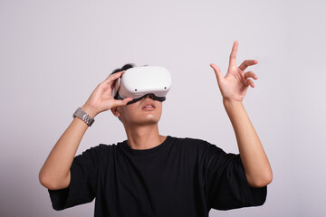 Surprised teen male student use vr glasses and looks at empty copy space .Virtual gadgets for entertainment, work, free time and study. Virtual reality metaverse technology concept.