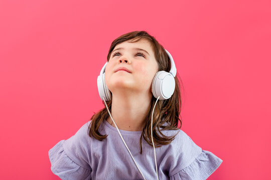 Joyful girl listening to music in headphones in studio