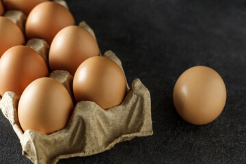 Chicken eggs, whole in cardboard tray, selective focus.