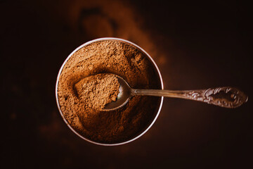 In an open jar there is a fragrant natural cocoa powder and a beautiful teaspoon. Instant drink....