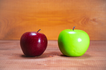 Red and green apple on a wooden background: the difference between apple varieties, the benefits and harms of different apple colors