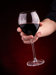glass of red wine on a red background.