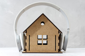 Wireless headphones on a toy wooden house close-up
