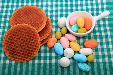 A composition view with apple waffles and colorful almond candies.
