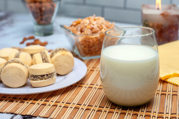 glass of milk with cornstarch alfajores nuts and cereals for a healthy breakfast or snack