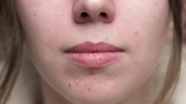 Close-up face of a caucasian young woman. Smell and smell. Movement of the wings of the nose.