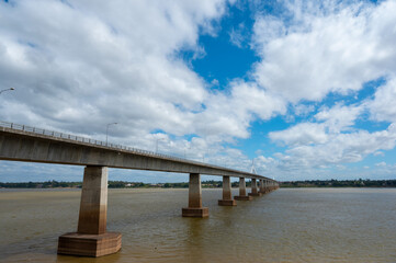Fototapeta na wymiar Landscape of Mukdahan Thai-Laos Friendship Bridge II viewpoint at Mekong river in cloudy blue sky background at Mukdahan province, Thailand.