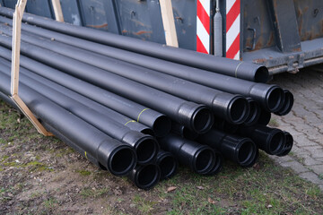 lot of new black pipes for protecting electrical wires lie on the ground, concept of repairing...