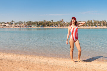 A girl in a fashionable swimsuit is sunbathing on the beach in a resort town in Egypt